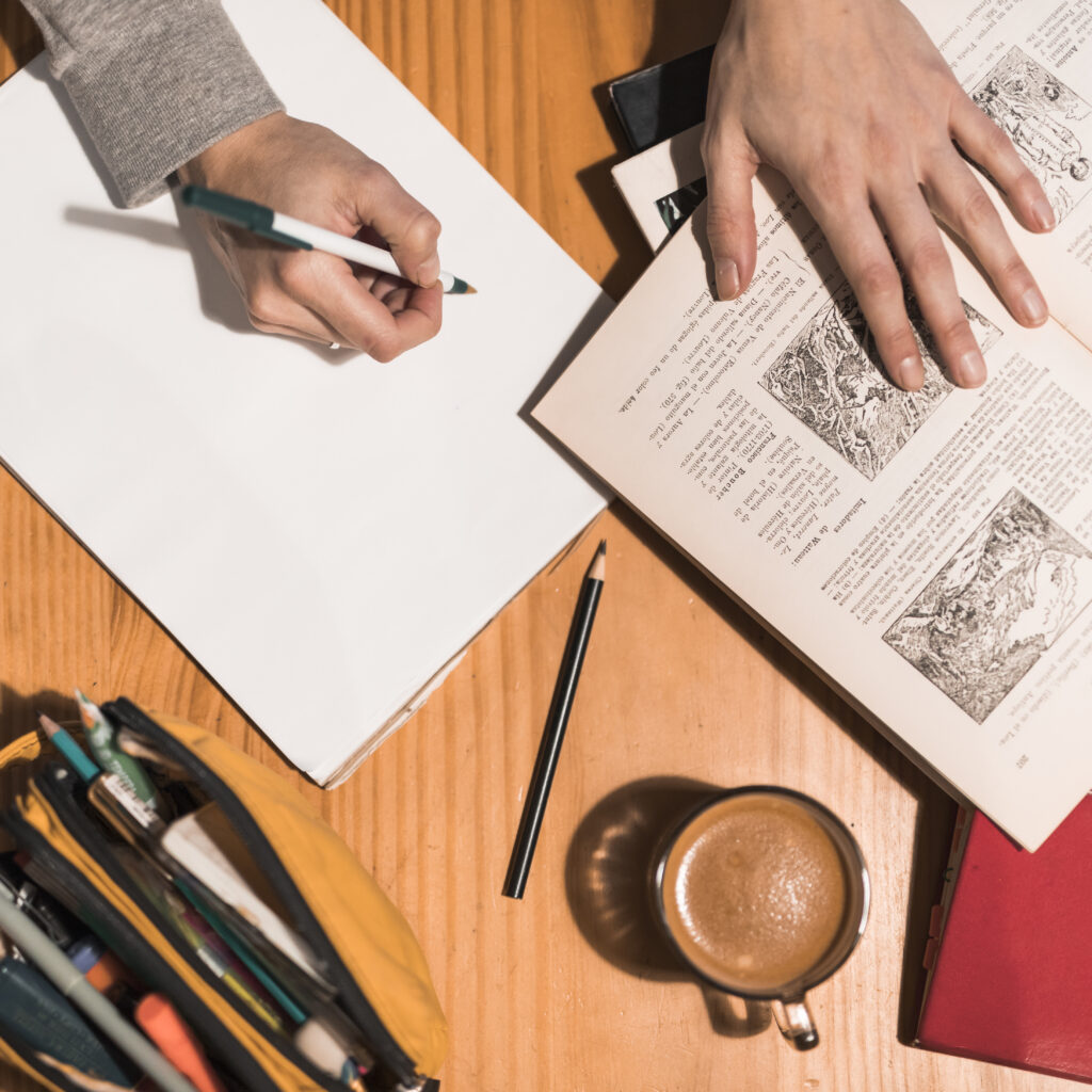 Person writing a book summary with notes