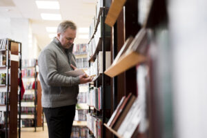 man looking at book to find Book Publishers in Arkansas
